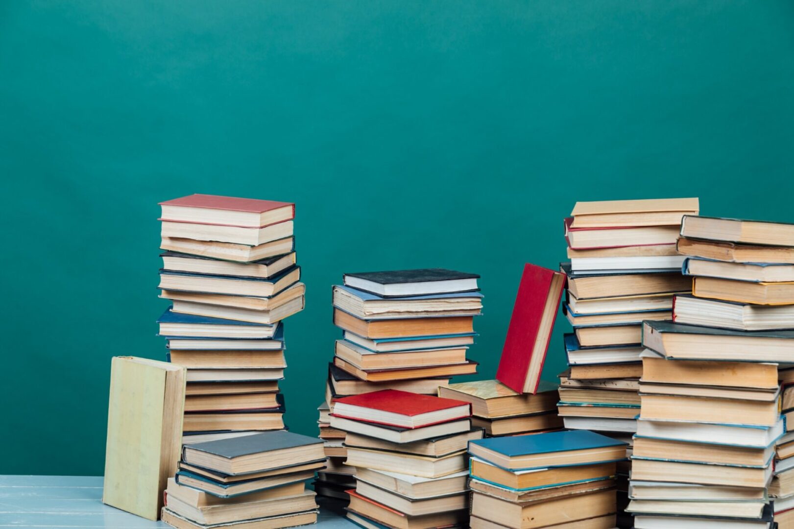 Stacks of books against a green background.