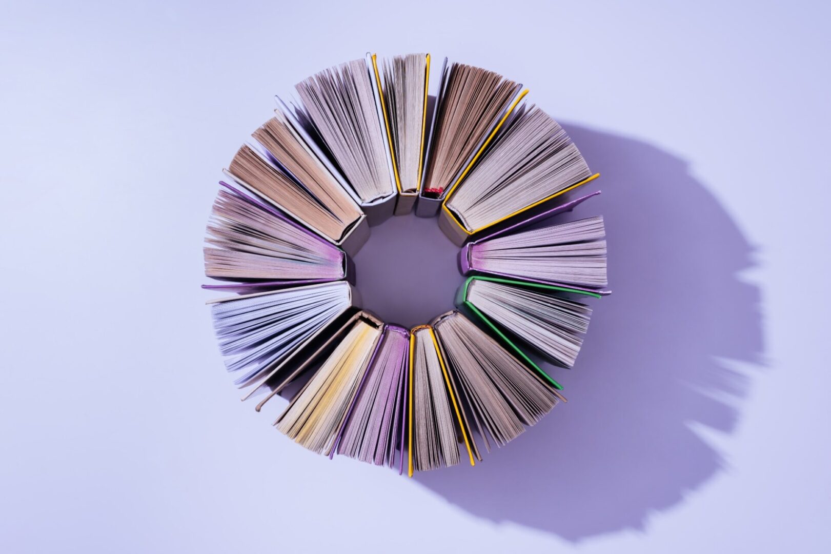 Circle of open books on table.